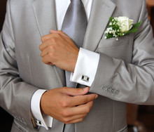 Groom In Grey Suit Ficing His Cufflink