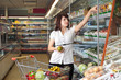 © Pumba - Beautiful young woman standing with a trolley at a supermarket