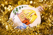 Christmas ball with a drawn house in a golden garland with stars