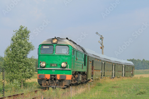 Naklejka ścienna Passenger train passing through polish countryside