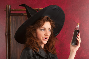 Young redhead witch with potions