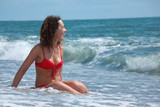 Fototapeta  - beauty girl sits in sea surf
