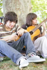 Wall Mural - garçon avec téléphone près d'une fille jouant de la guitare