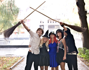 Group of people with broom and halloween witch costume.