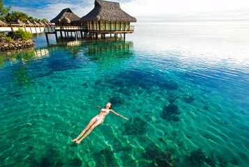 Wall Mural - young woman swimming in a coral lagoon