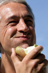 Mature man eating pear