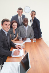 Wall Mural - Five business people in a meeting smiling at the camera