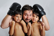Young man with black boxing gloves and two children