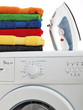 verschiedenfarbige Wäsche und Bügeleisen auf der Waschmaschine freigestellt auf weißem Hintergrund