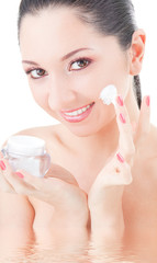 Poster - Woman applying cream to her face on the white background