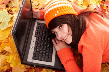 Wall Mural - girl in autumn orange leaves with laptop.fall sale.