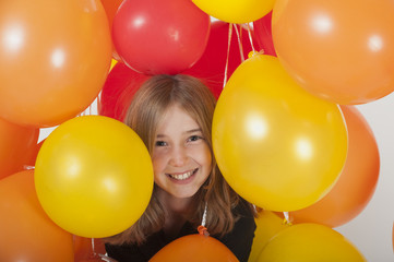 girl (10 years old) smiling big and surounded by balloons