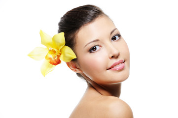 Wall Mural - smiling female face with yellow orchid from her ear