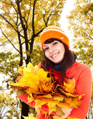 Wall Mural - girl in autumn orange hat with leaf group near tree. outdoor.