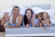 © WavebreakMediaMicro - Young family playing in bed together