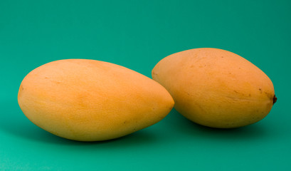 Ripe mango on a green background