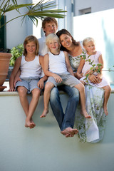 very happy family sitting on wall