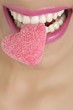 Heart shape candy on woman macro mouth
