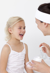 Wall Mural - Mother and daughter having fun with cream