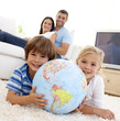 © WavebreakMediaMicro - Children playing with a terrestrial globe at home