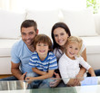 © WavebreakMediaMicro - Portrait of happy family smiling in living-room