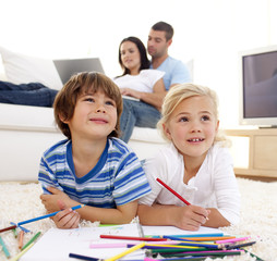 Wall Mural - Children painting in living-room and parents on sofa