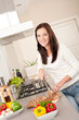 © CandyBox Images - Smiling woman cutting bread in the kitchen