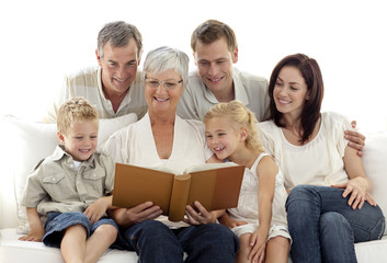 Grandmother reading a book to her family