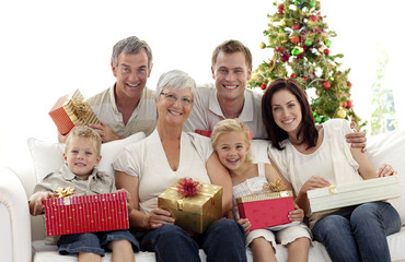 Wall Mural - Family holding Christmas presents at home