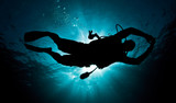 male diver silouette in deep ocean