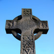 tombstone in shape of a cross on a cemetery