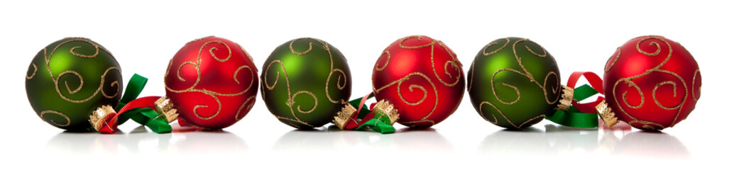red and green christmas ornaments with ribbon on white