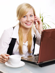 smiling blond woman sitting in office and calling by phone