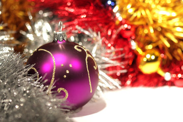 purple christmas ball with gold pattern on abstract tinsel backg