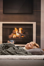 Woman Resting Beside Fireplace