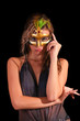 Beautiful woman in mask on black background