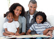 © WavebreakMediaMicro - Portrait of an Afro-American family reading a book in the living