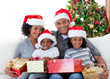 © WavebreakMediaMicro - Afro-American family holding Christmas presents