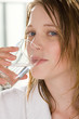 canvas print picture - Frau im Bademantel trinkt ein Glas Wasser