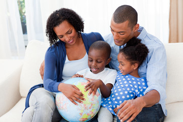 Wall Mural - Happy family holding a terrestrial globe