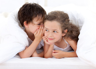 Wall Mural - Siblings playing on parent's bed