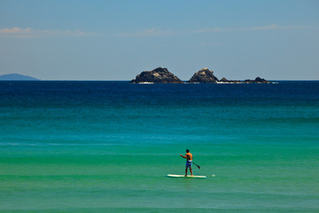 paddle surfing to rocks in byron bay