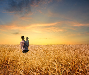 man in wheat field with boy