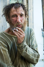 Sad Homeless Man Smoking A Cigarette Outdoor