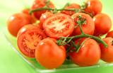 Fototapeta Kuchnia - dojrzale czerwone pomidory na talerzu, na zielonym tle, grono
