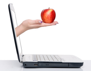 hand with apple and laptop