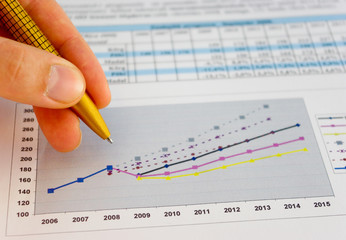 Hand with pen pointing to the chart