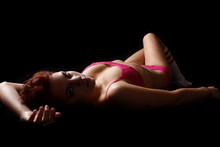 Young woman wearing pink lingerie and socks.