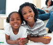© WavebreakMediaMicro - Happy siblings drawing lying on the floor