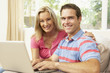 © Monkey Business - Young Couple Using Laptop At Home